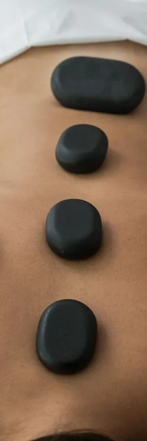 Piedras calientes sobre una espalda durante una sesi&oacute;n de masajes.